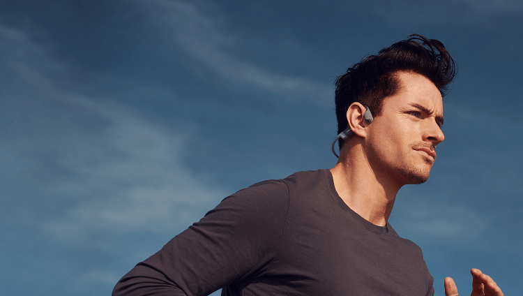 Un homme sportif portant OpenRun Shokz, casque sport haut de gamme à conduction osseuse.